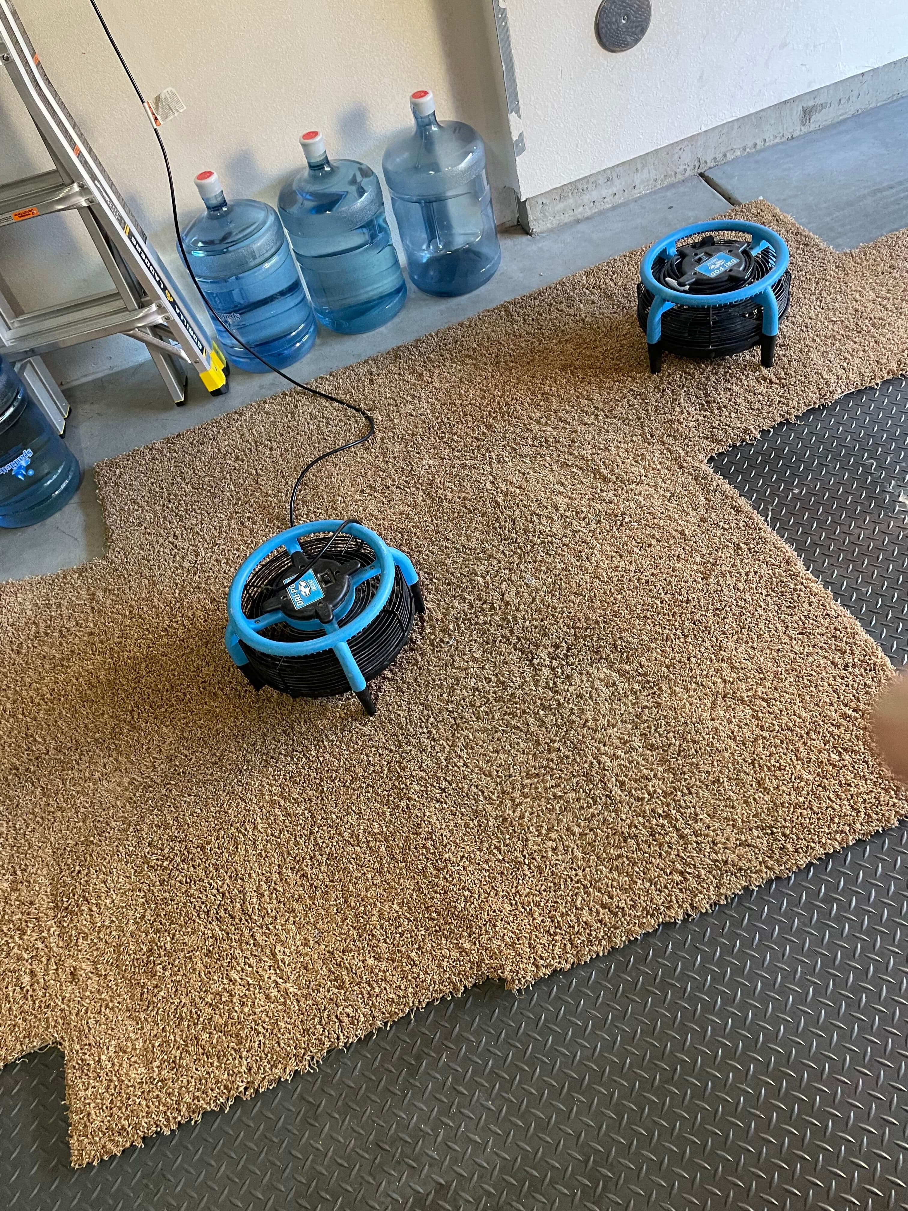 Air mover positioned on a drying hardwood floor